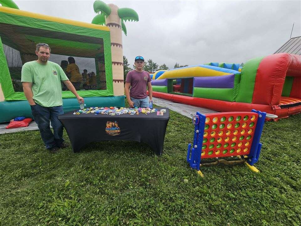 Bounce Buddies booth with a palm tree bounce house, obstacle course and giant 4-to-score at the GiGi's Playhouse 5K at Otto Armleder Park