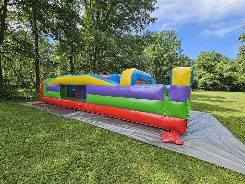 Retro inflatable obstacle course set up in a wooded backyard in Goshen Township, Ohio