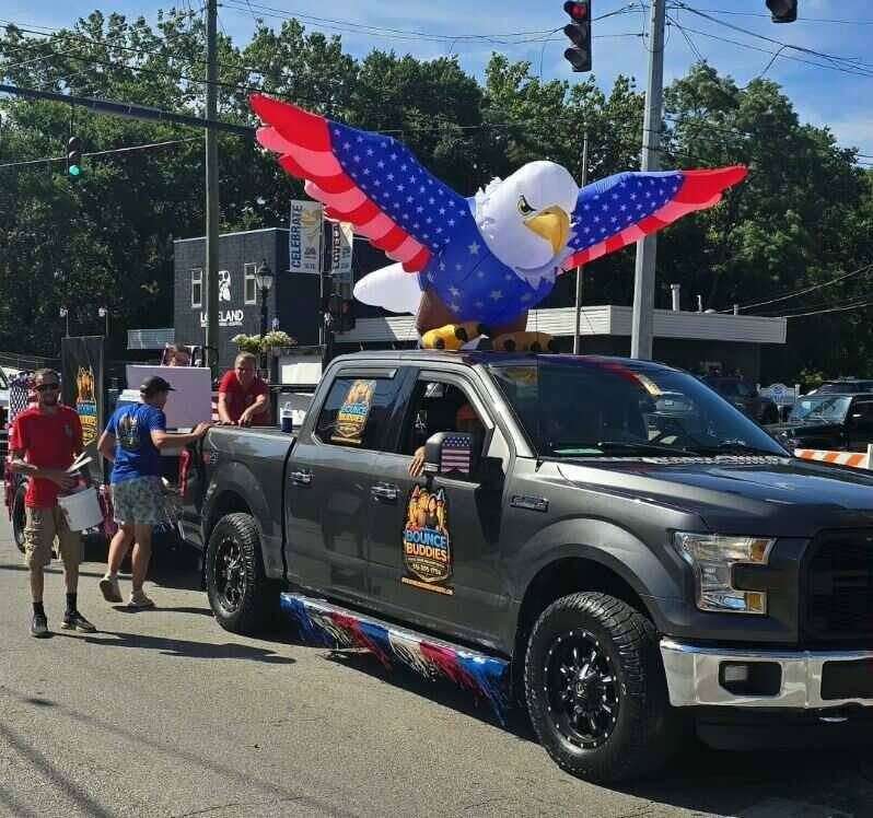 Bounce Buddies truck with a giant inflatable eagle in the Loveland Independence Day parade downtown