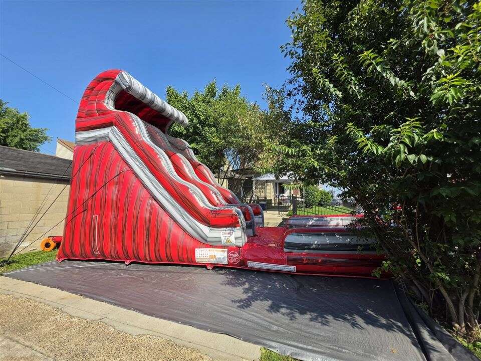 Red Lava Wave inflatable water slide set up on pavement in Newport, Kentucky
