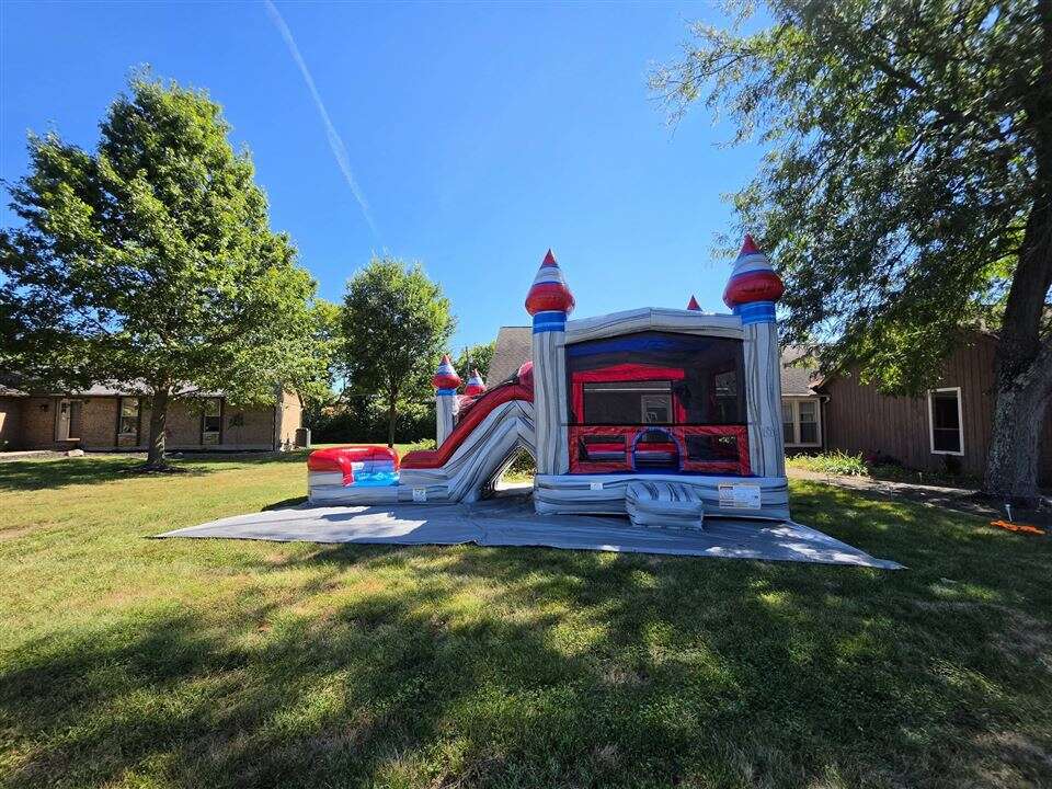 Silver and red Titanium dual lane bounce house combo set up in a backyard in West Chester, Ohio