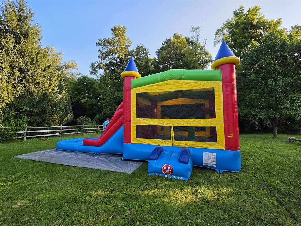 Castle bounce house with slide set up in a backyard in Amelia, Ohio