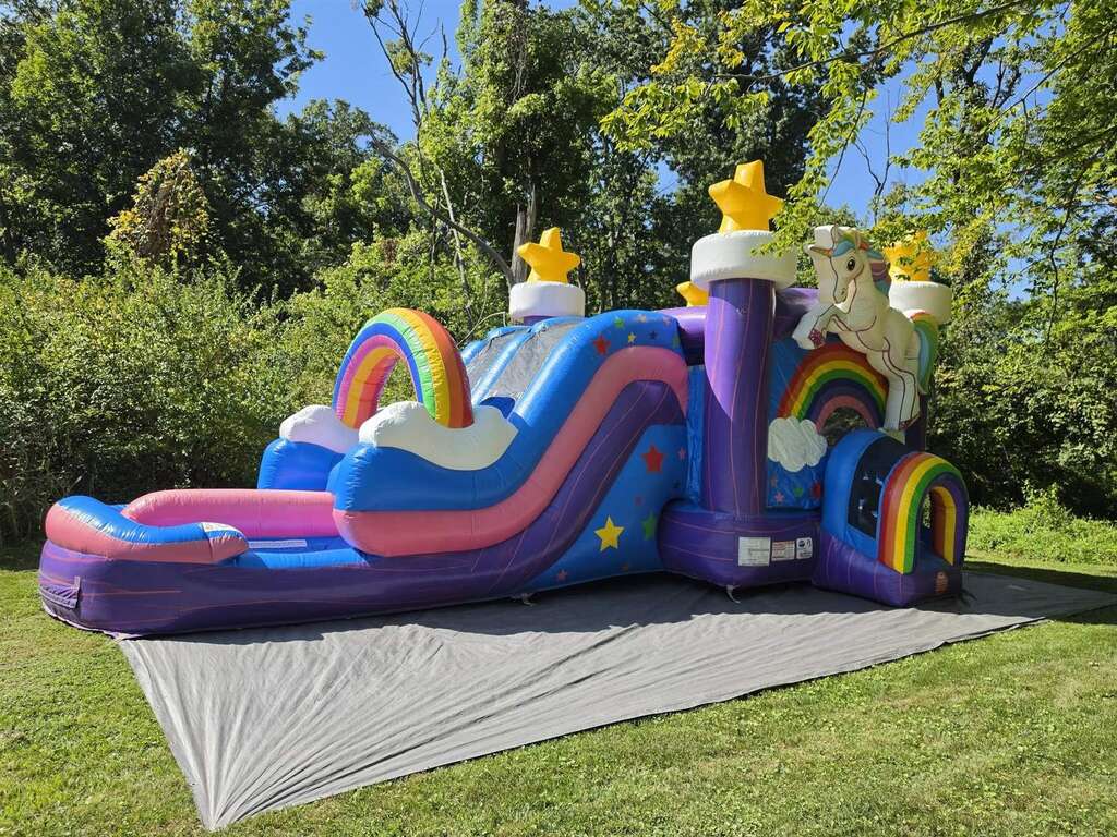 Unicorn rainbow bounce house and slide combo set up at a party in Anderson Township, Ohio