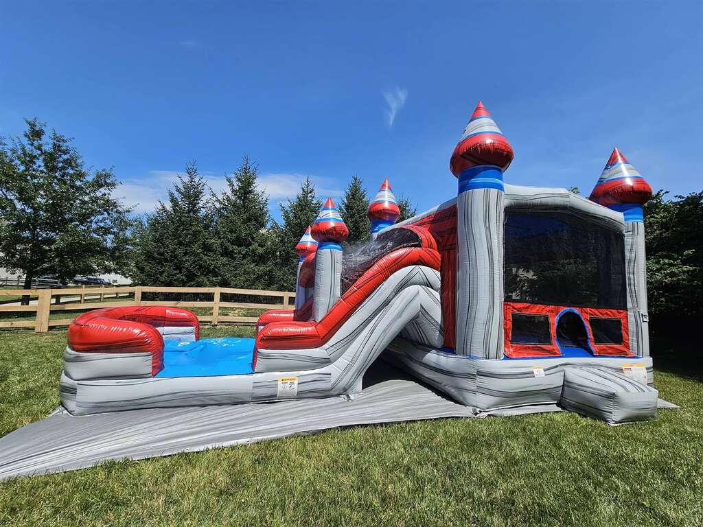 Silver and red castle bounce house combo with slide at a party in Batavia, Ohio