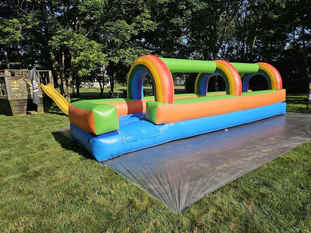 Rainbow inflatable slip and slide set up in a backyard in Mason, Ohio