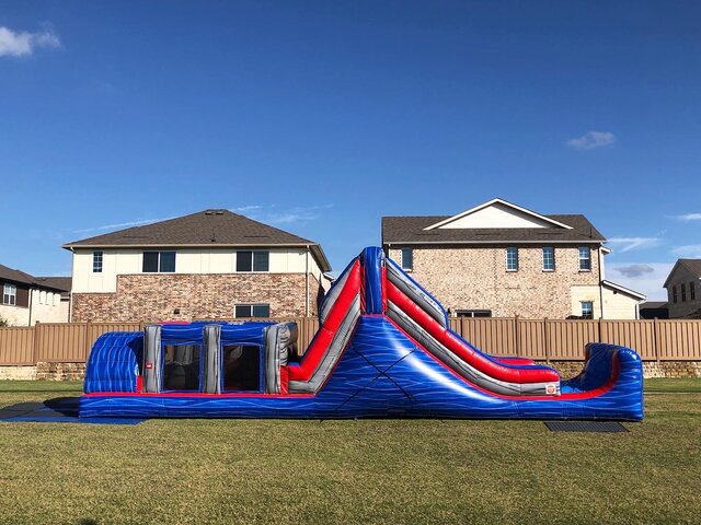 40-foot blue rush inflatable obstacle course with water on grass at school event