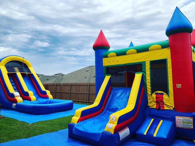 Colorful combo bounce house with slide on grass in backyard for party.