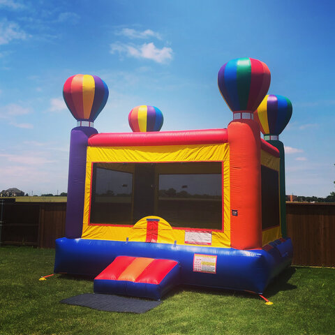 15' X 15' balloon themed bounce house on grass in back yard.