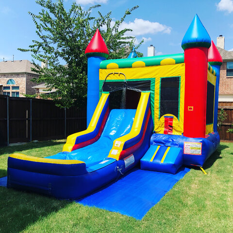 Colorful combo bounce house with water slide and pool on grass in backyard.