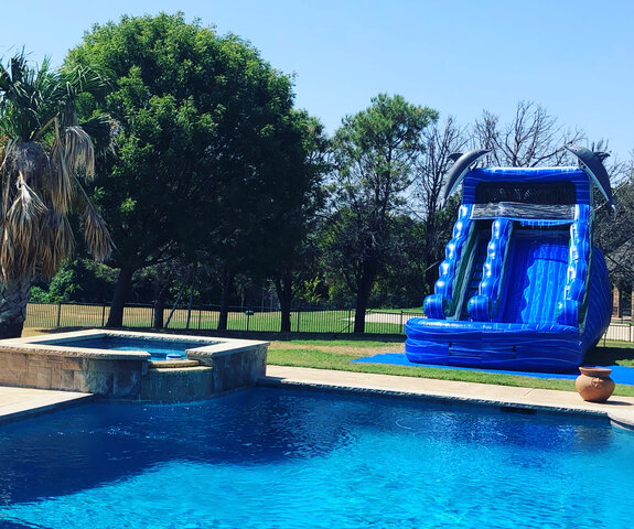 15-foot laguna dolphin water slide with pool on grass next to inground pool