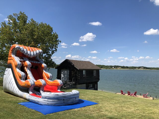 15-foot inflatable lava tidal wave water slide with pool on grass with lake Lewisville in background