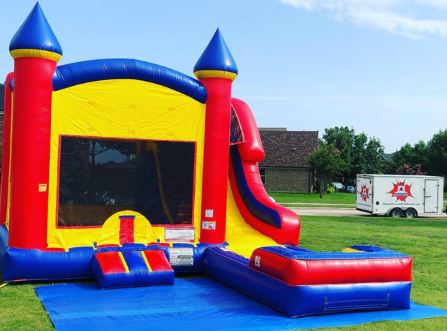 Large bounce house with water slide, pool, and basketball hoop on grass for an HOA community event.
