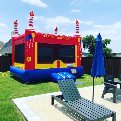 Inflated birthday bounce house on grass next to inground pool near Frisco Texas.