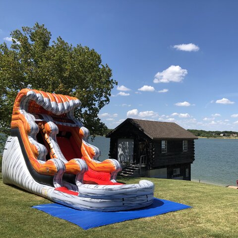15-foot inflated lava tidal wave water slide with pool on grass with Lake Lewisville in background, Little Elm Texas.