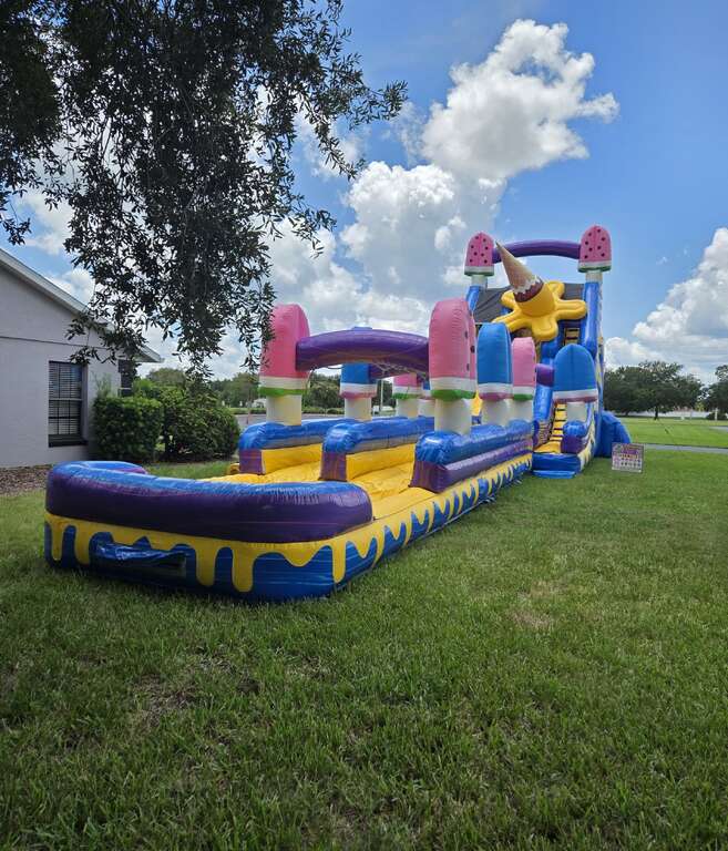 25-foot Ice Cream double-lane water slide with pool set up on grass beside a church building in Saint Cloud, FL