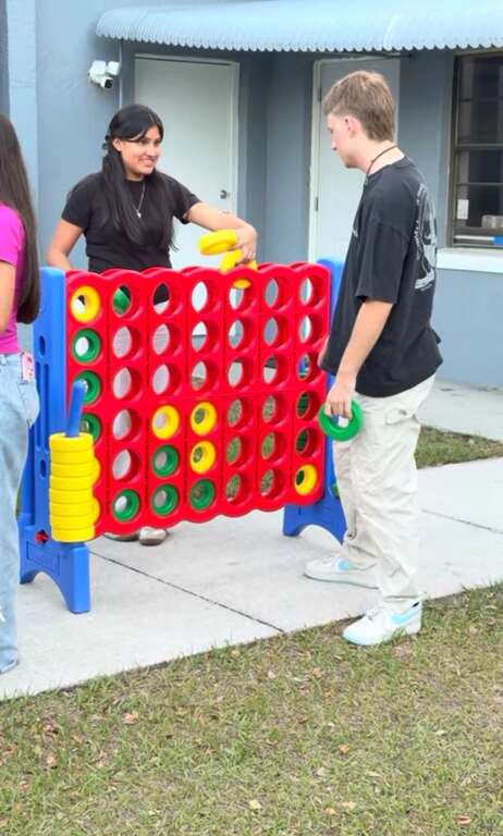 Two students playing a giant Connect Four yard game at a church youth event in Saint Cloud, FL