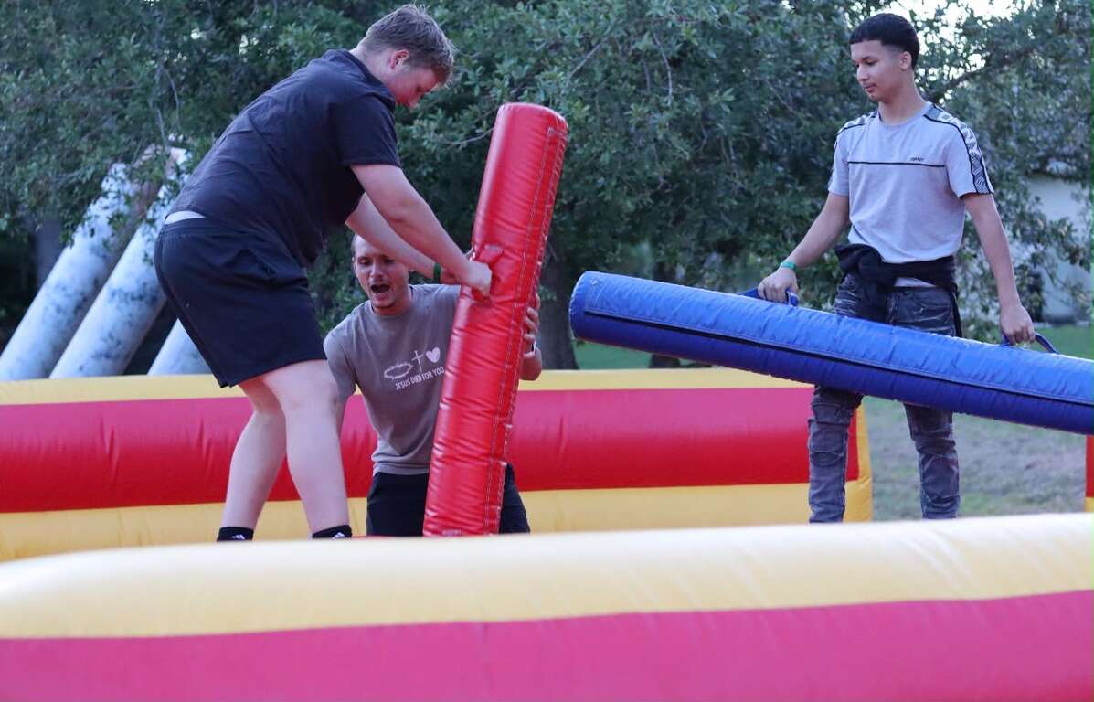 Two people battling on the Joust Gladiator inflatable arena at a church youth event in Saint Cloud, FL