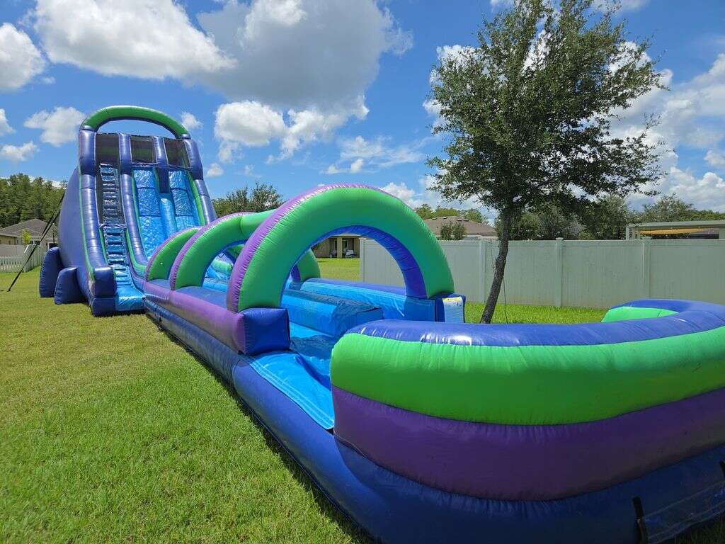 Double lane water slide rental set up in a Saint Cloud, FL backyard for a full weekend rental