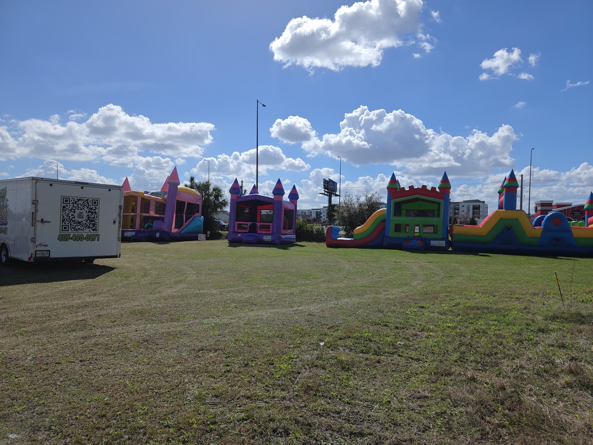 Bounce houses, combos and an obstacle course lined up on an open field for a large community event