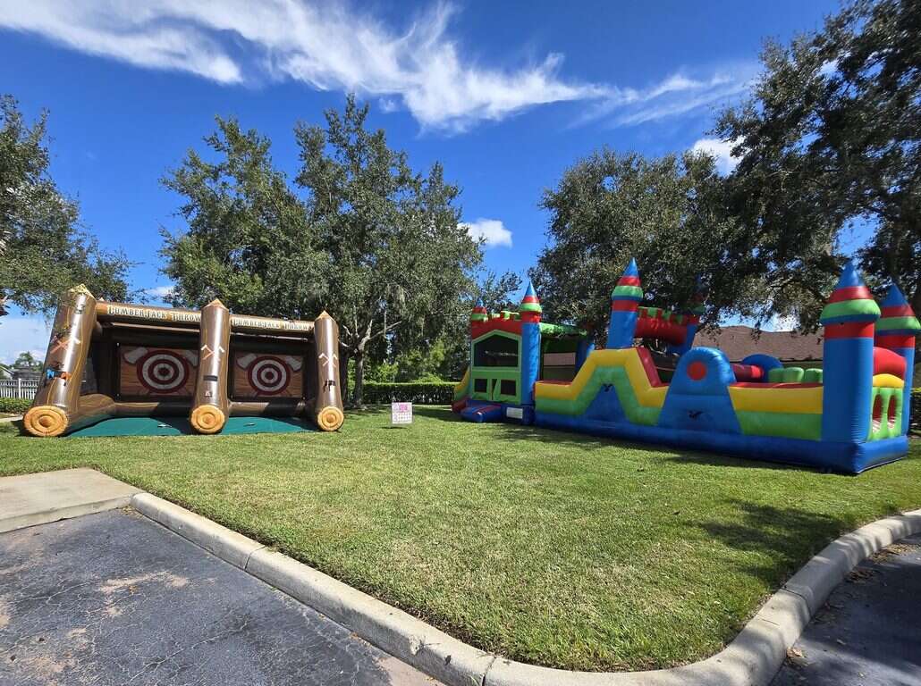 Lumberjack-style dual axe throwing game and a multicolor obstacle course set up on the grass for the Indian Lakes HOA Halloween party in Saint Cloud, FL
