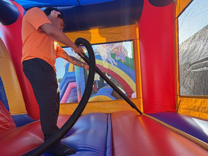 A Bounce Party of Tampa crew member vacuuming the floor inside a bounce house