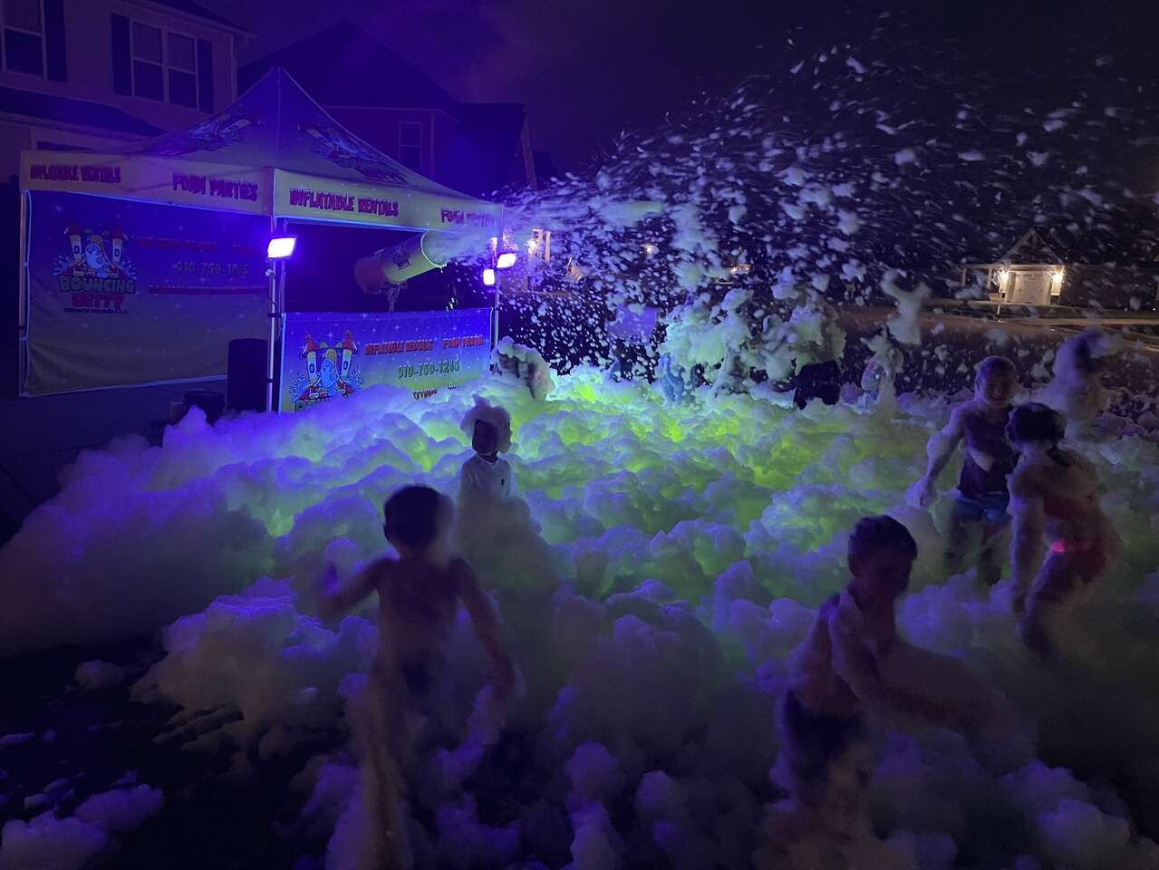 Kids playing in glow in the dark foam at a foam party
