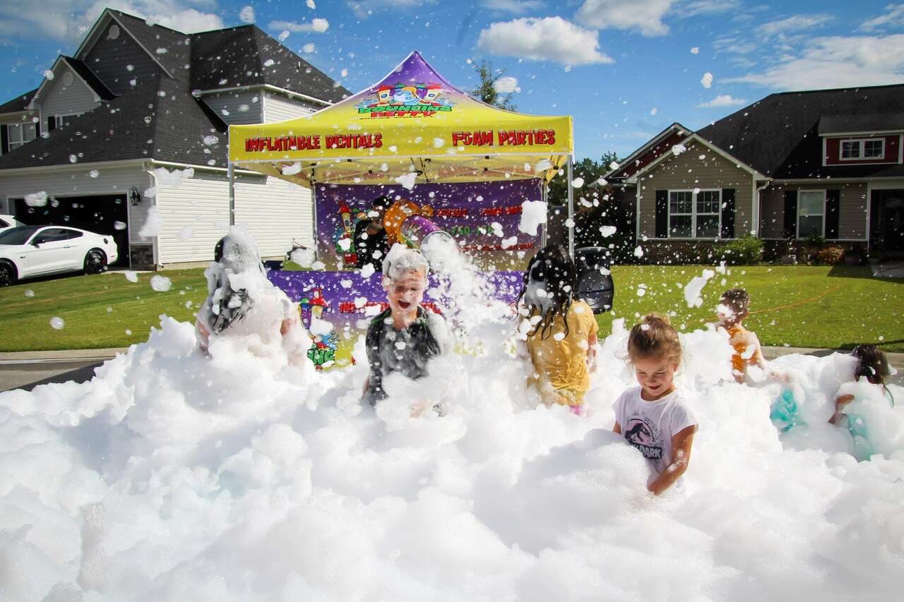 kids playing happily in foam at an outdoor foam party