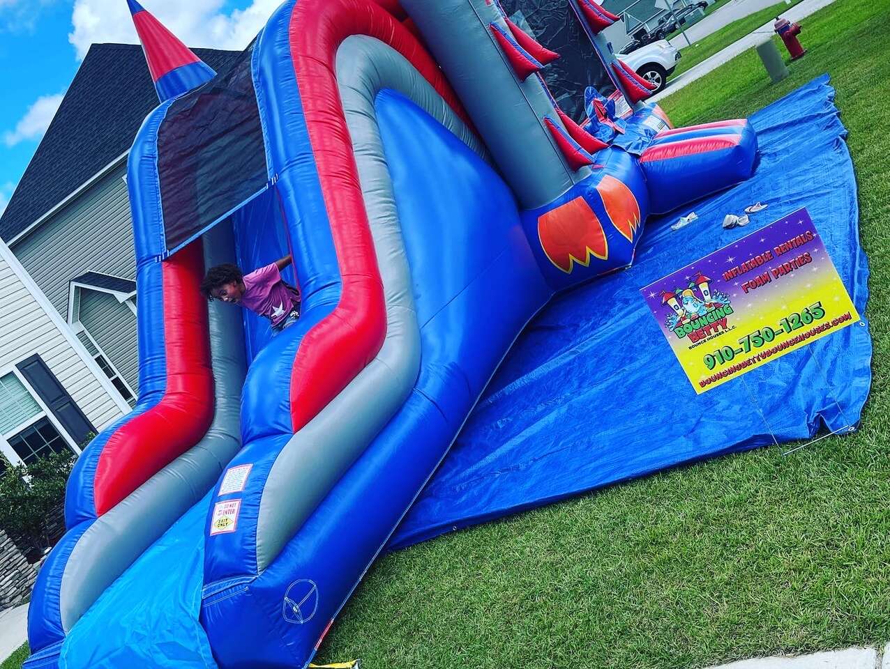 Girl sliding down a bounce house with a slide