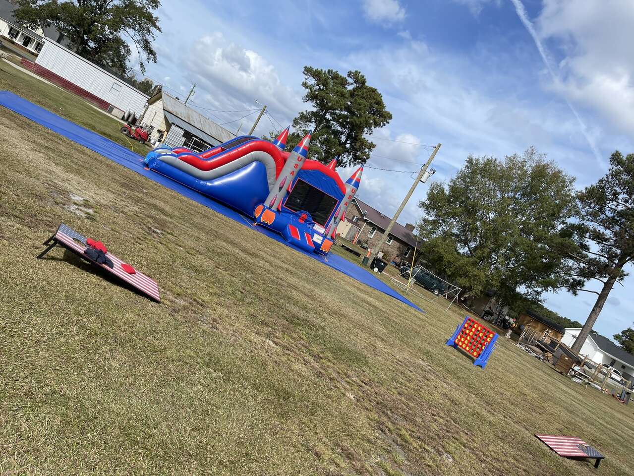 Rocketship inflatable bounce house and slide next to yard games