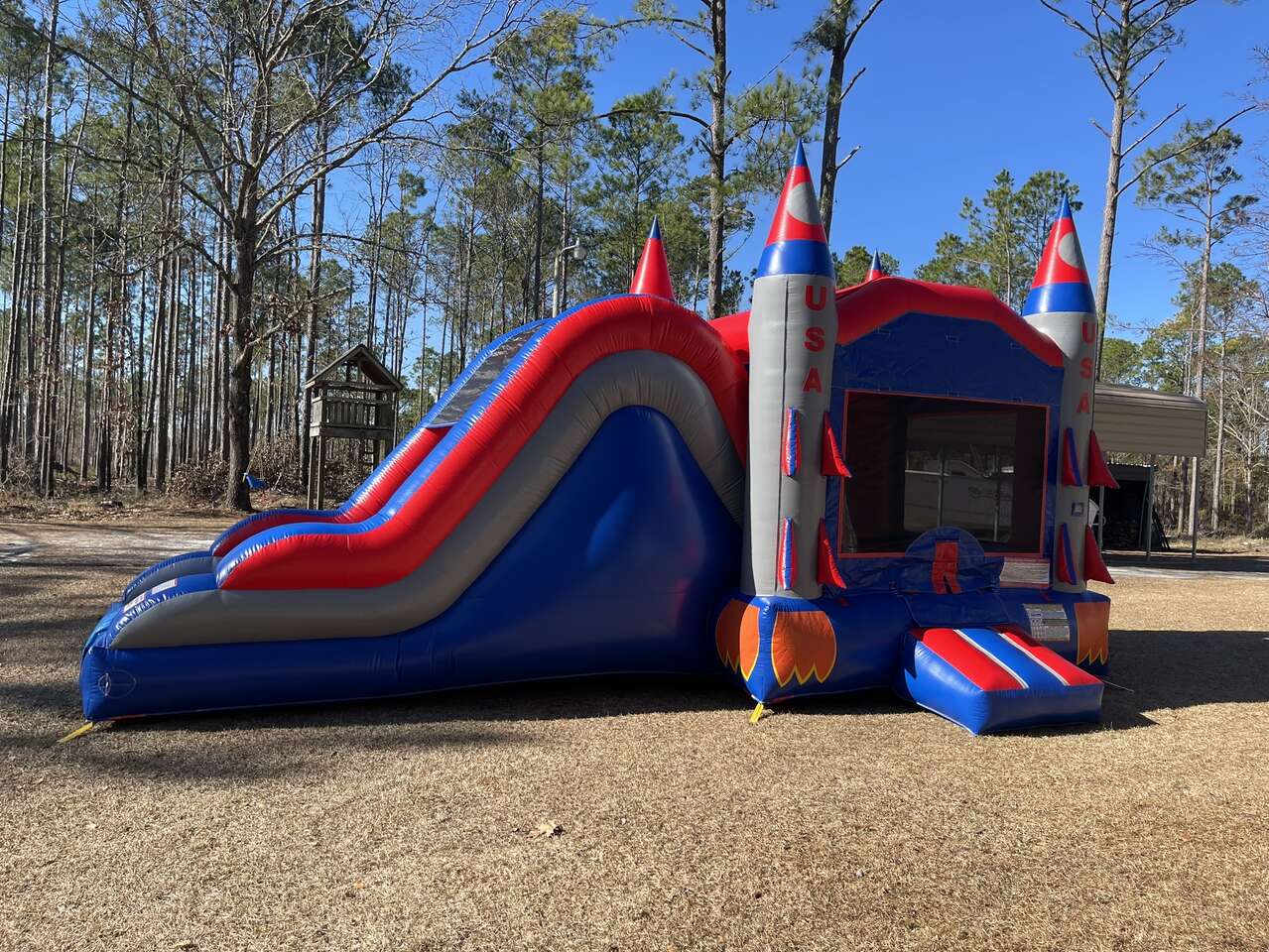Blue, red, and gray USA rocket themed bounce house with slide