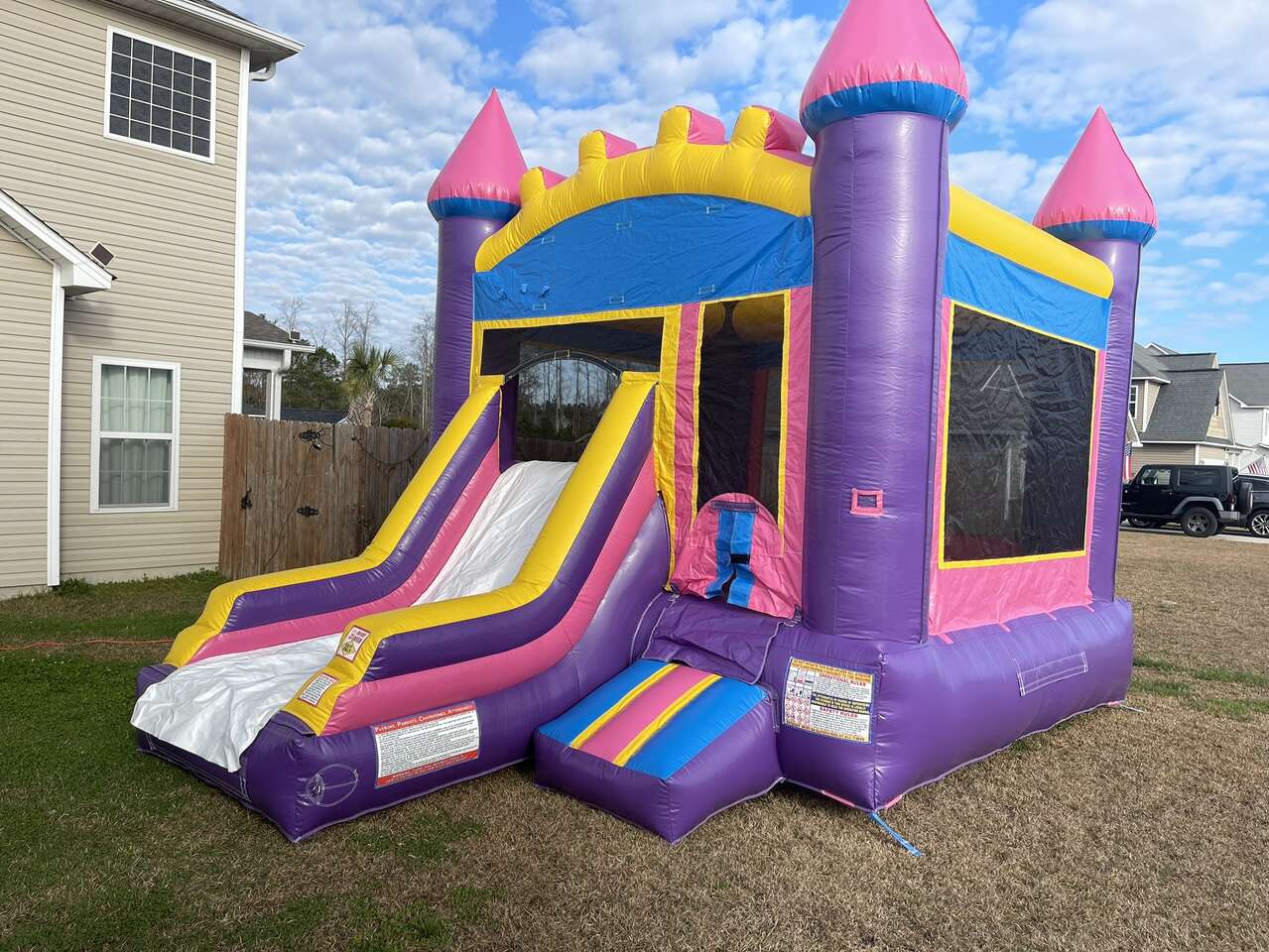 purple and pink bounce house with slide