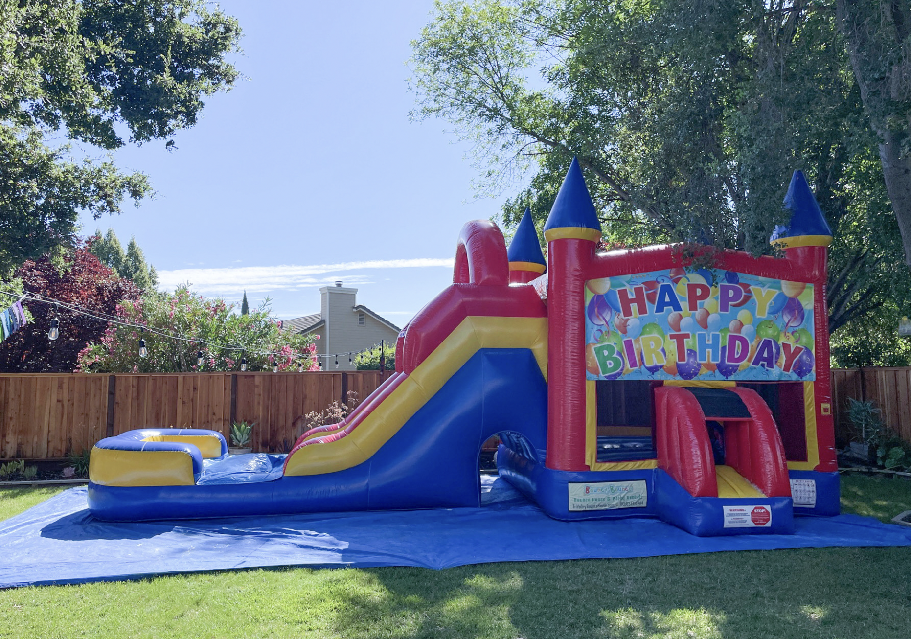 5-in-1 Combo Slide bounce house with water slide, Happy Birthday theme, set up in a backyard