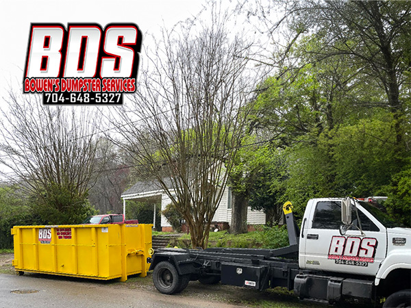 Empty Bowen's Dumpster Services container positioned ready for use on a residential driveway.