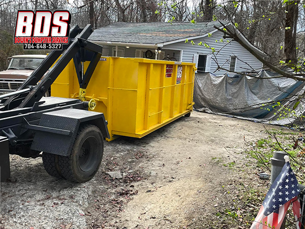 A before and after shot of a clean jobsite, thanks to Bowen's Dumpster Services' yellow dumpster. 