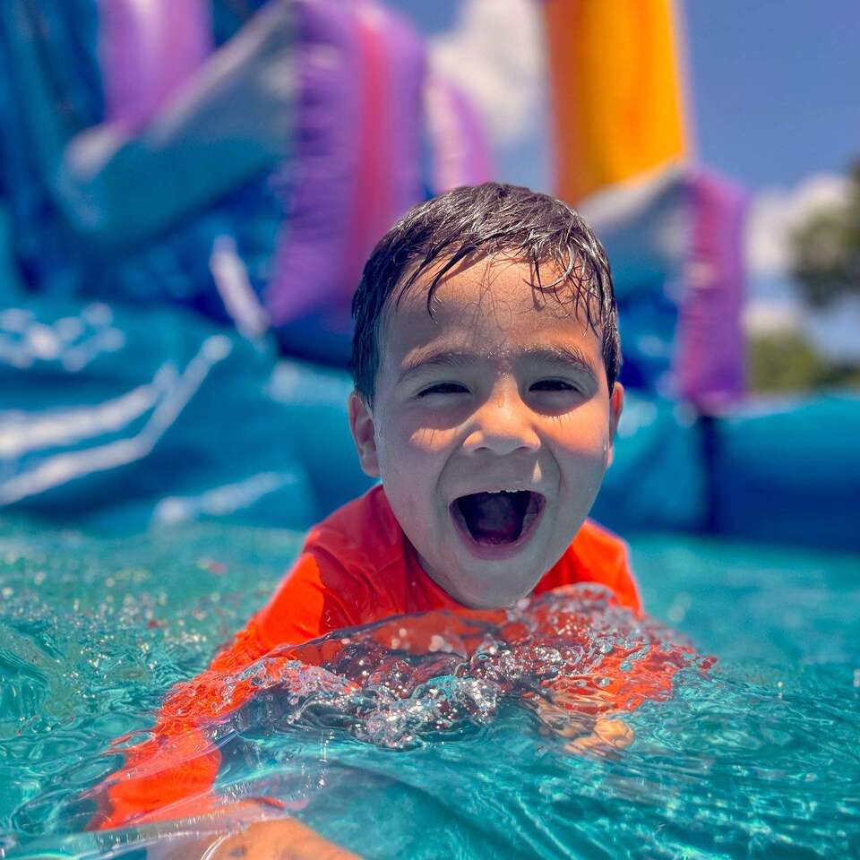 kids jumping in a bounce house smiling