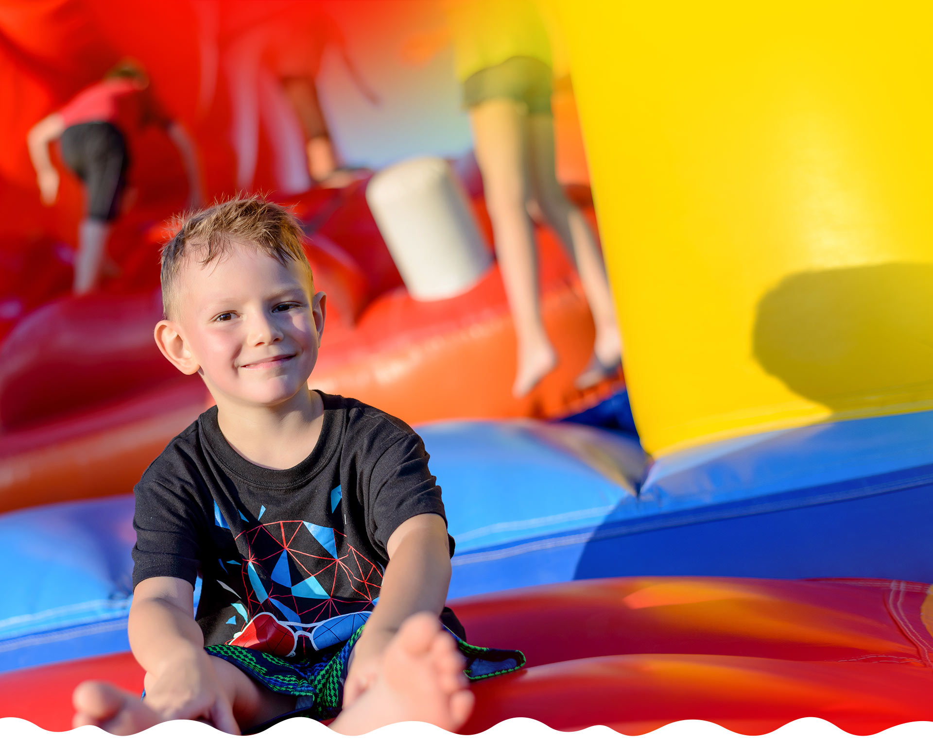 kids jumping in a bounce house smiling