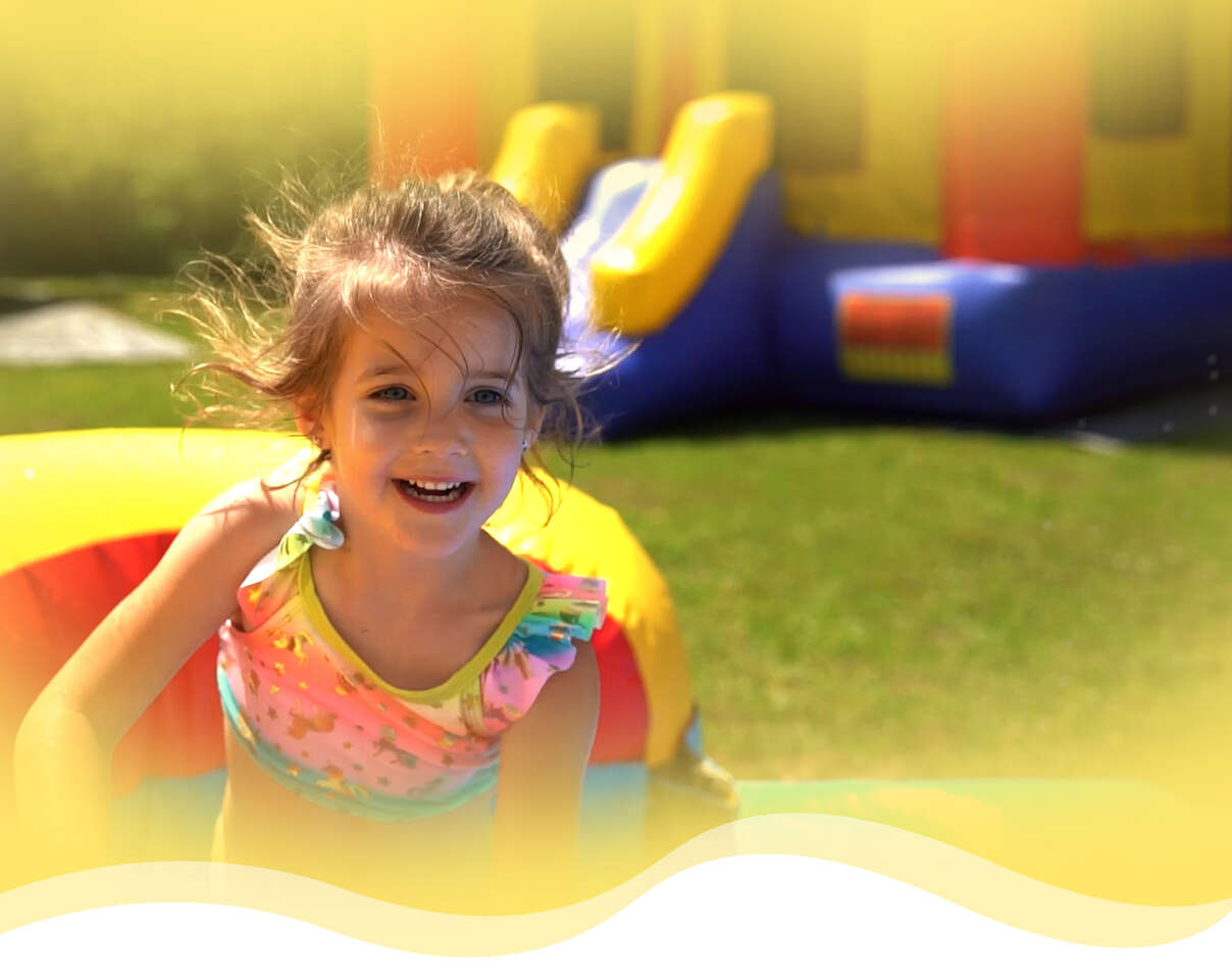 kids jumping in a bounce house smiling