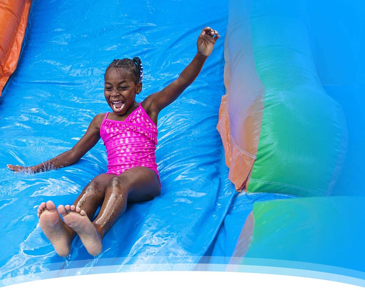 kids jumping in a bounce house smiling