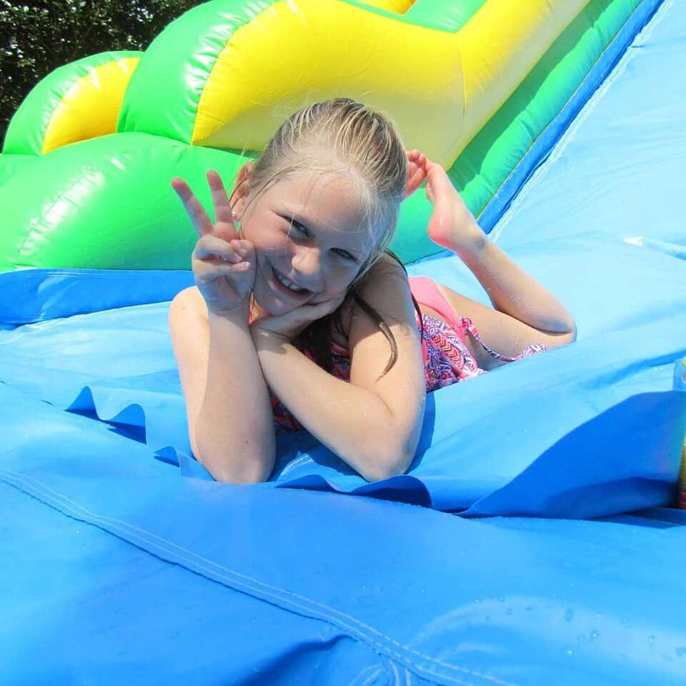 Children having fun and smiling playing on a waterslide