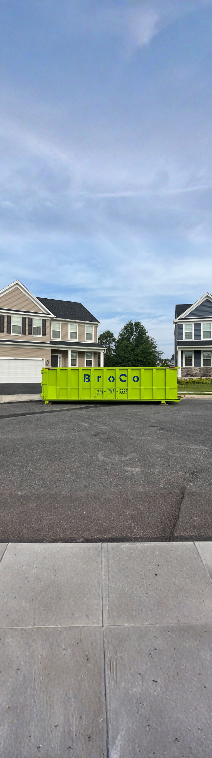 Broco Waste residential dumpster placed in a suburban driveway.