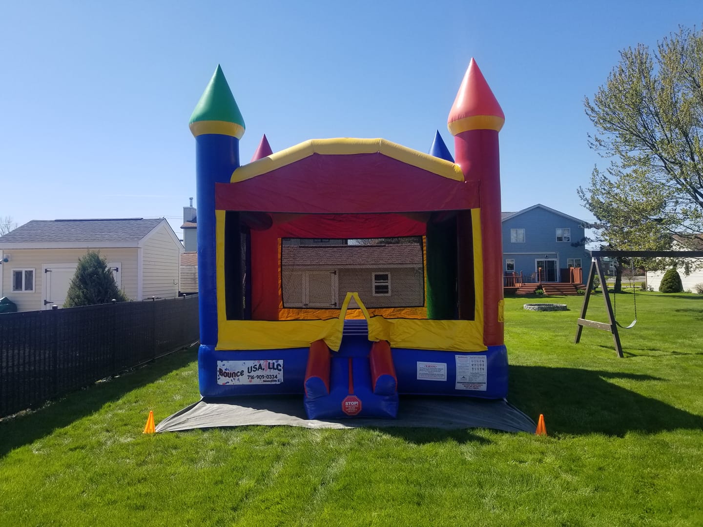 colorful castle bounce house set up for a birthday party
