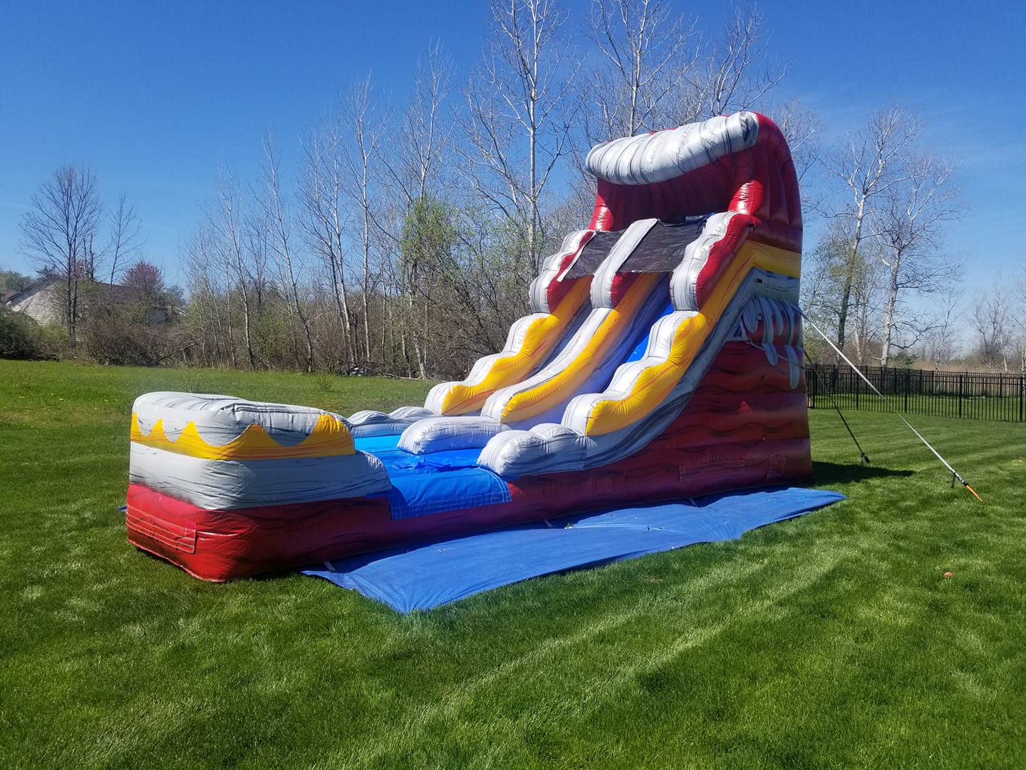 Red, grey and yellow slide set up outside for a fun in the sun day