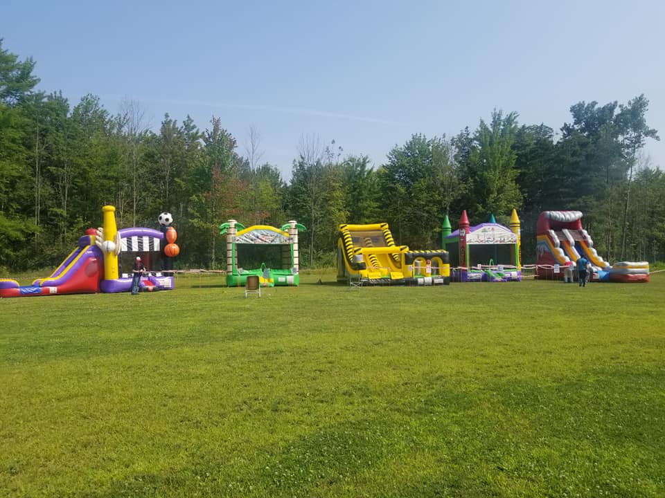 Lots of different inflatable bounce houses being used at a large community event in Buffalo, NY