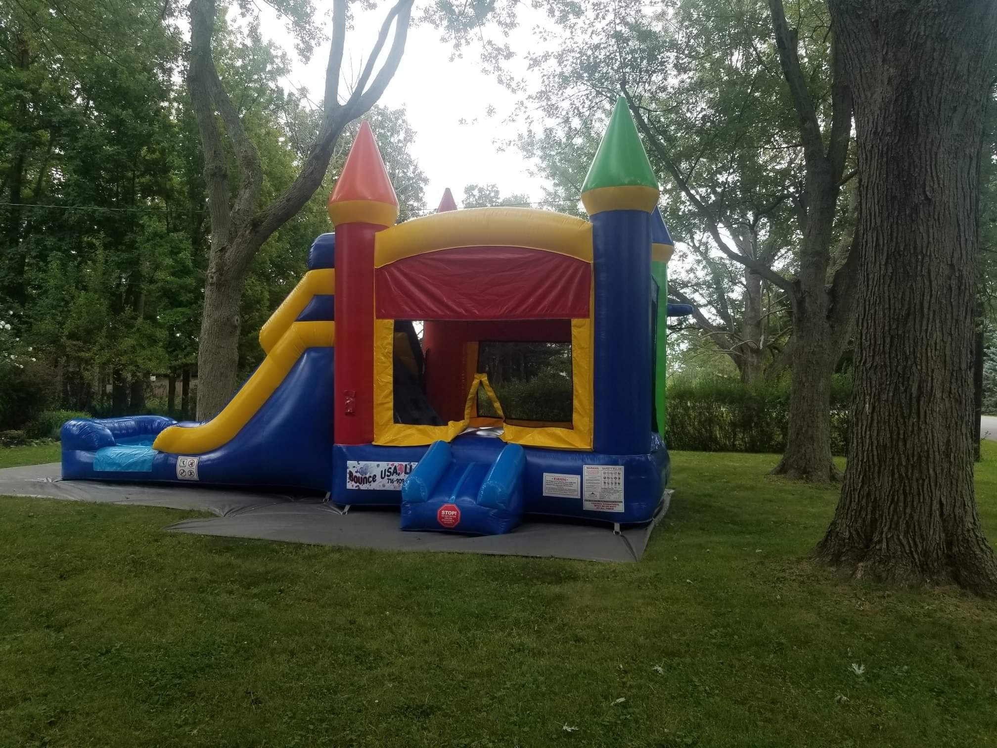 Big multi colored bounce house with slide that can be used as a water slide