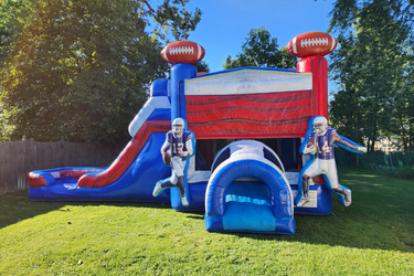 Tropical safari bounce house with bright green leaves next to a cation tape looking inflatable obstacle course