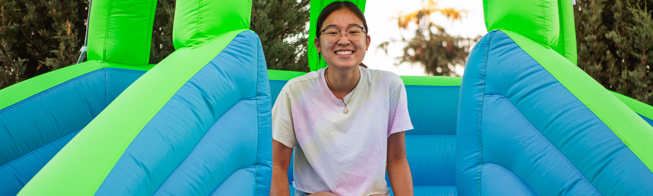 Kid on inflatable water slide at party