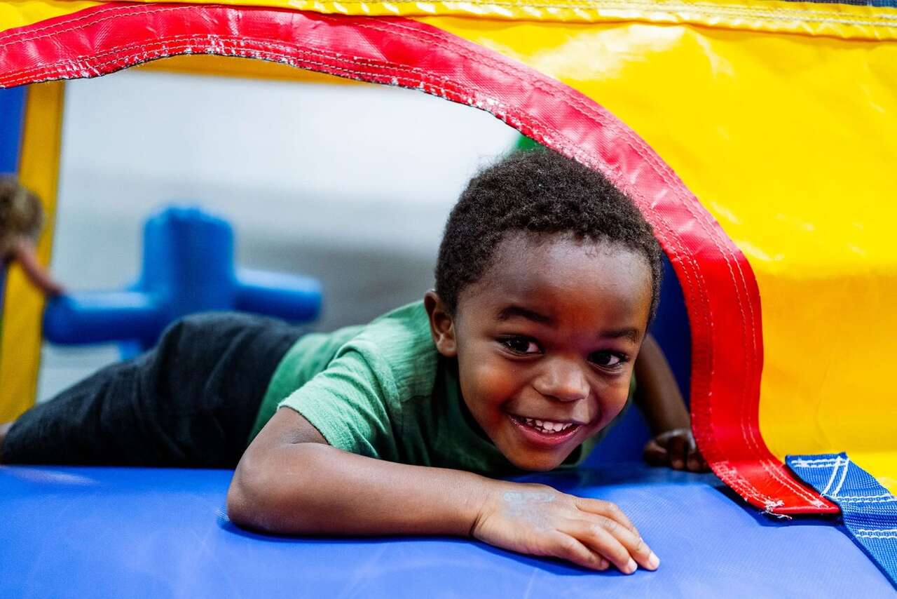 Smiling young boy playing in a colorful bounce house rental in Boardman, OH Smiling young boy playing in a colorful bounce house rental in Boardman, OH