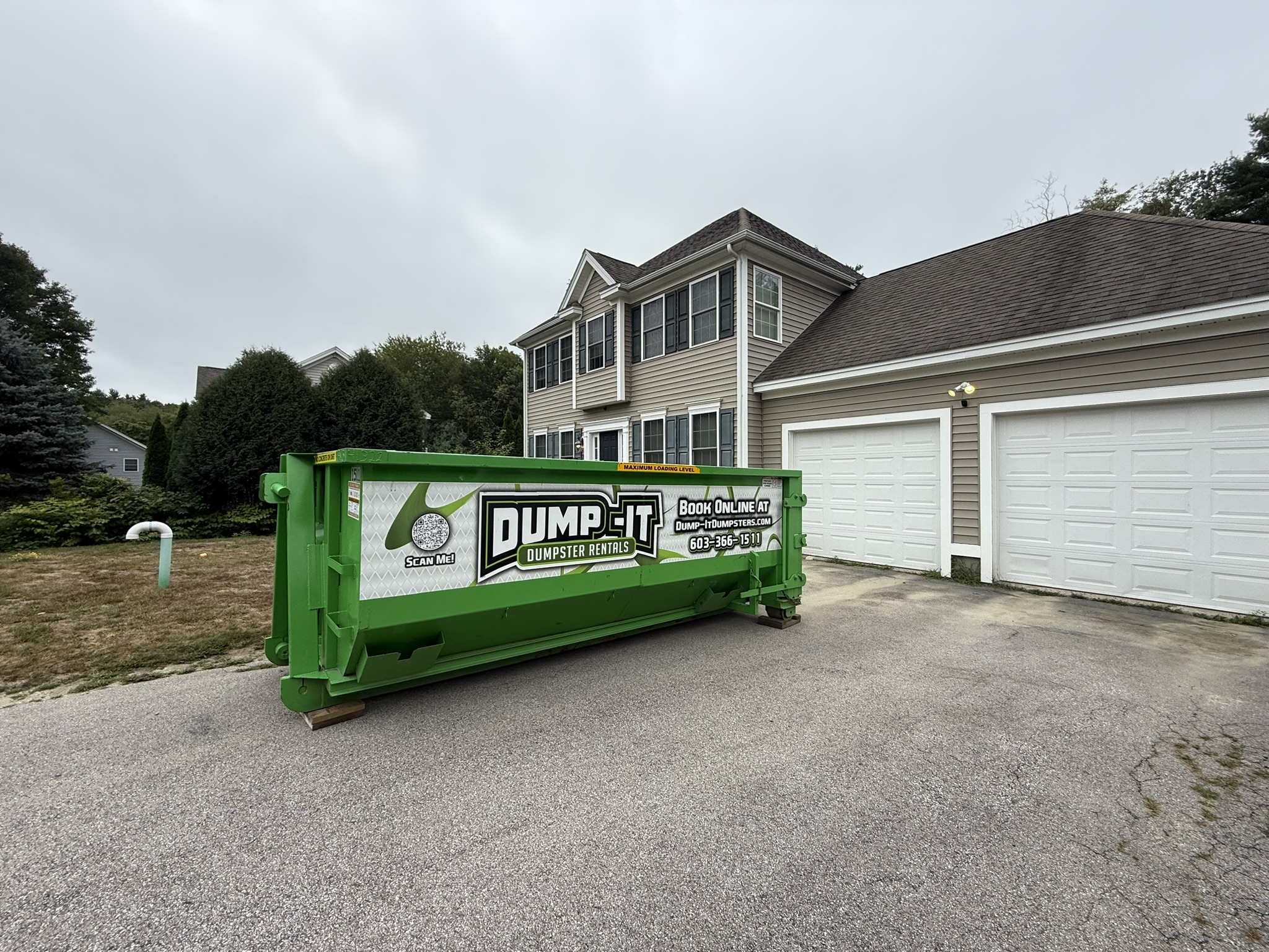 Dump-It Dumpster Rentals" logo over a green dumpster in a driveway.