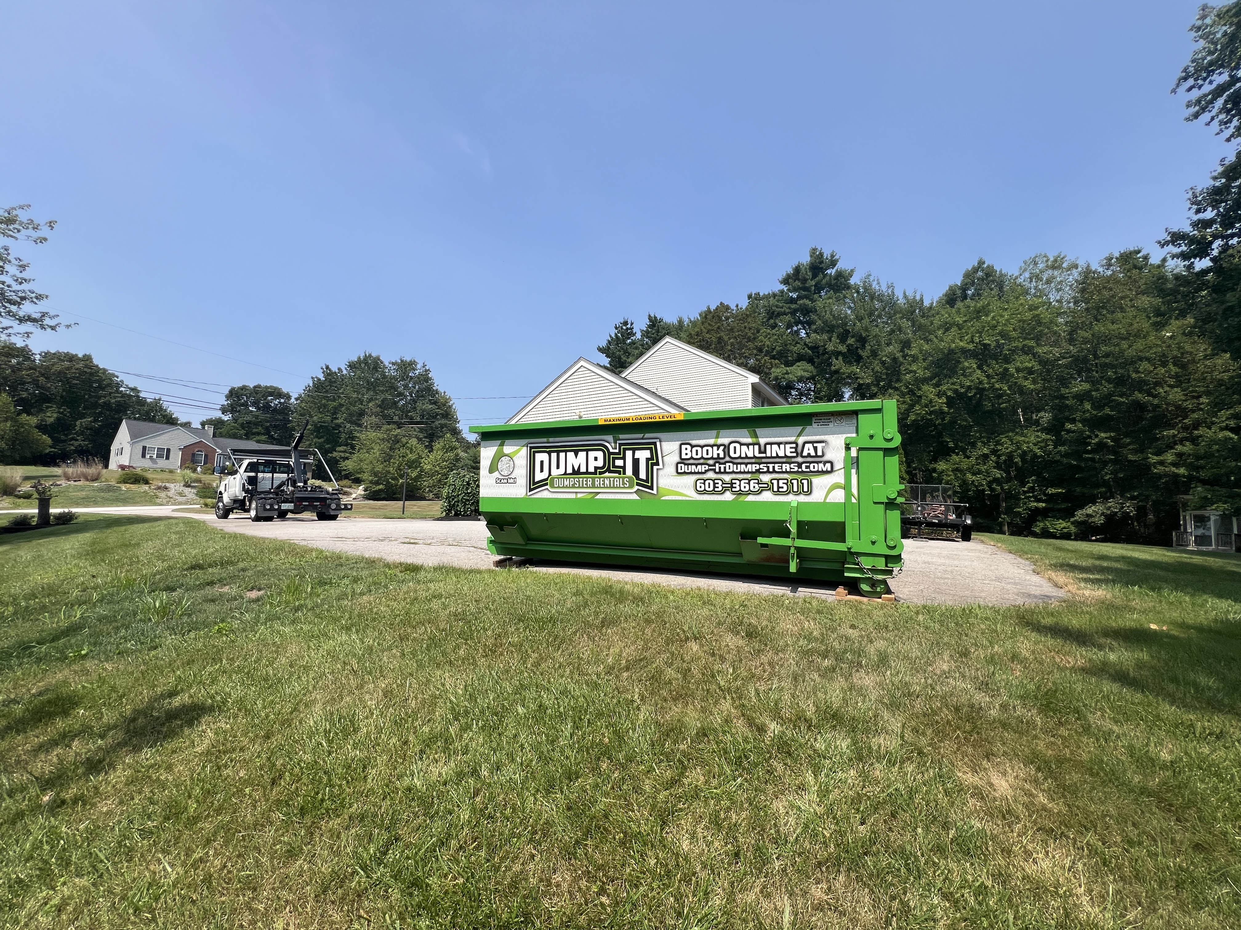 Residential dumpster from Dump-It Dumpster Rentals placed in a backyard