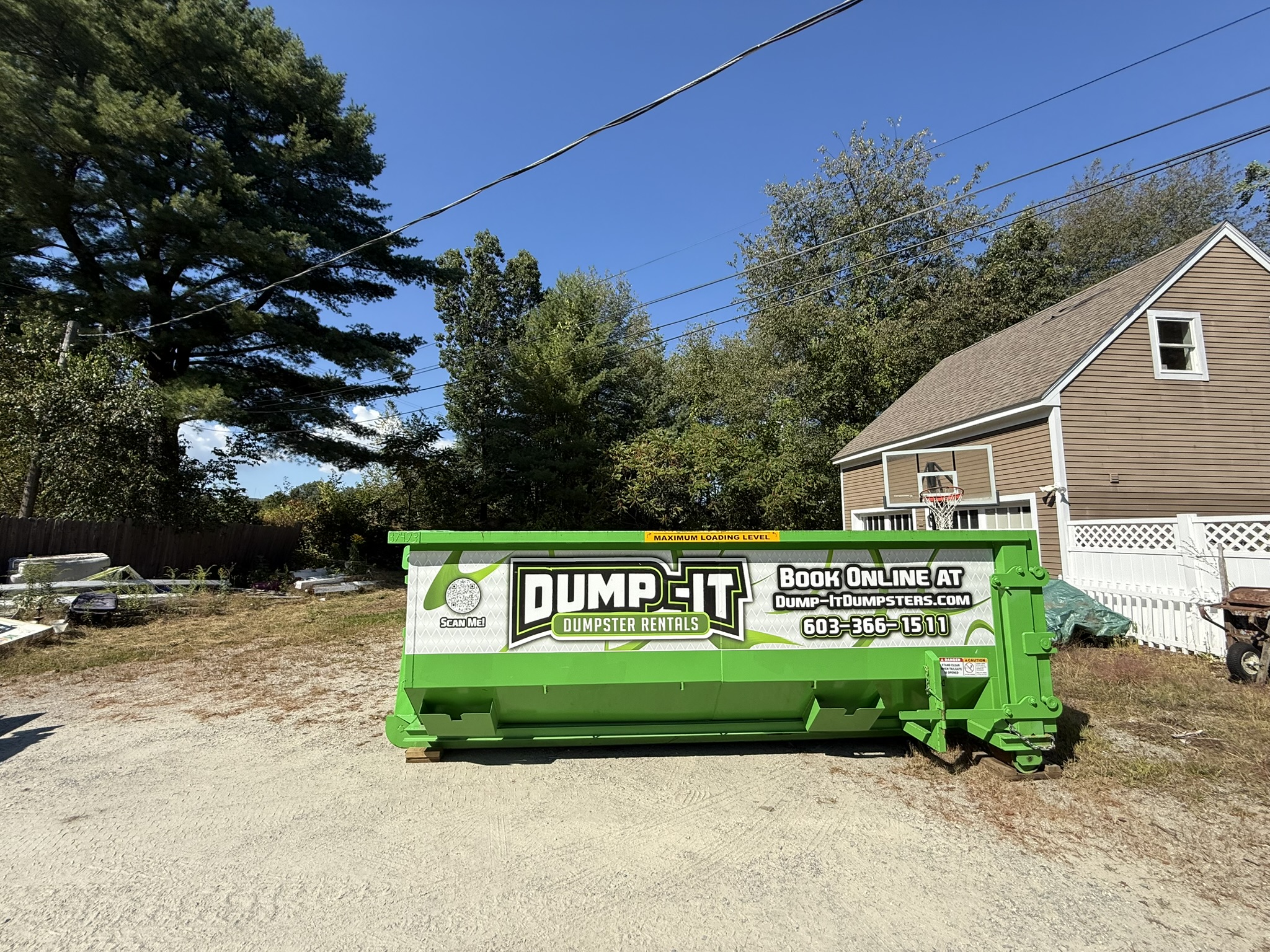 Dump-It Dumpster Rentals" logo over a green dumpster in a driveway.